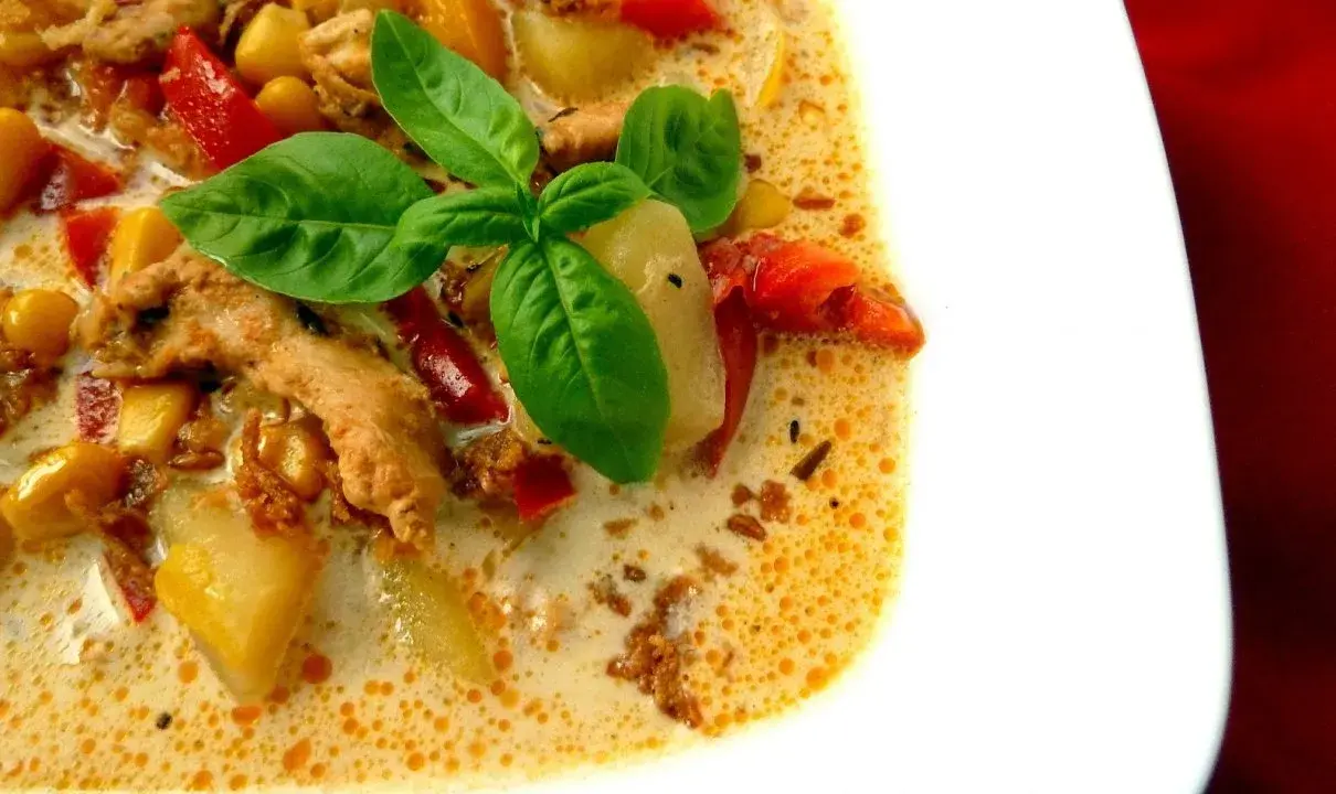 Zupa gyros Ania gotuje: kremowa, sycąca, z kawałkami kurczaka, ziemniaków i papryki, ozdobiona listkami bazylii.