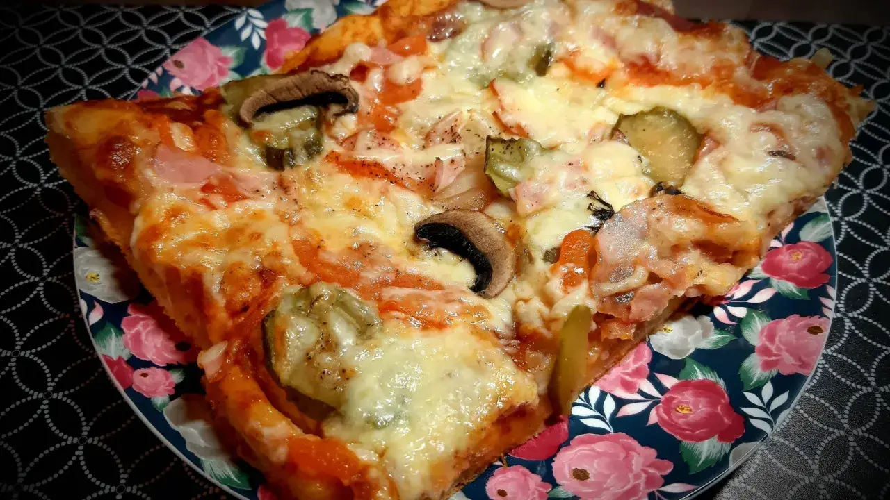 Pyszny domowy przepis na pizzę z pieczarkami, ogórkiem i szynką. Idealna na szybki obiad.