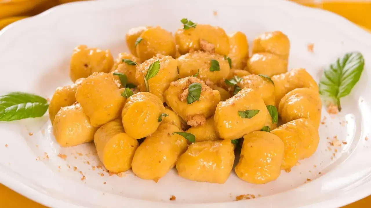 Kopytka z dyni wg Gesslerowej, delikatne i aromatyczne, posypane świeżą bazylią i okruszkami.