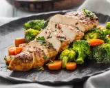 Soczysty filet drobiowy pokrojony w plastry, podany z chrupiącym brokułem i marchewką.