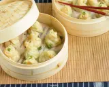 Para bułeczek na parze, czyli ciasto wonton, w bambusowych parownikach. Udekorowane szczypiorkiem.