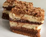 Warstwowe ciasto z serkiem mascarpone 250g, przełożone czekoladą i posypane kruszonką. Pyszny deser na talerzu.