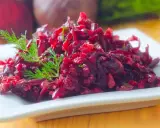 Prosta sałatka z buraków gotowanych, doprawiona koperkiem, podana na białym talerzu.