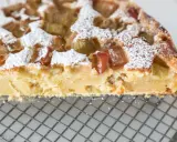 Pyszna babka z rabarbarem, posypana cukrem pudrem, idealna do pieczenia w temperaturze 180°C.