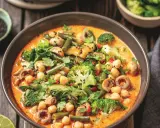 Kremowe curry z ciecierzycą, brokułami, fasolką szparagową i grzybami, posypane czarnym sezamem.