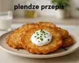 Plendze (placki ziemniaczane) z kwaśną śmietaną i szczypiorkiem na talerzu.