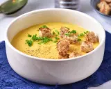 Aksamitna zupa z cukinii z ziemniakami i marchewką, udekorowana grzankami i natką pietruszki.