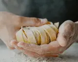 Dłonie trzymają świeży, pokrojony makaron. Zastanawiasz się, ile makaronu na porcję?