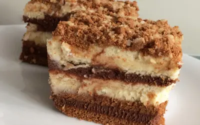 Warstwowe ciasto z serkiem mascarpone 250g, przełożone czekoladą i posypane kruszonką. Pyszny deser na talerzu.