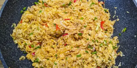 Pyszny ryż smażony z jajkiem, doprawiony papryczką chili i szczypiorkiem, gotowy do podania.