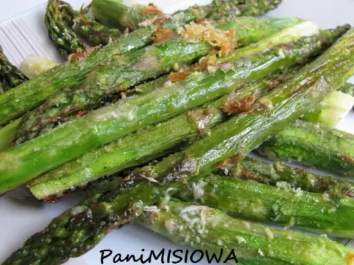 Pieczone szparagi z parmezanem na talerzu.