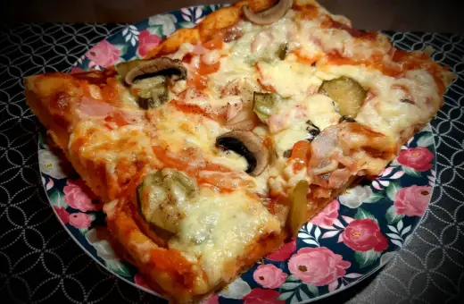 Pyszny domowy przepis na pizzę z pieczarkami, ogórkiem i szynką. Idealna na szybki obiad.