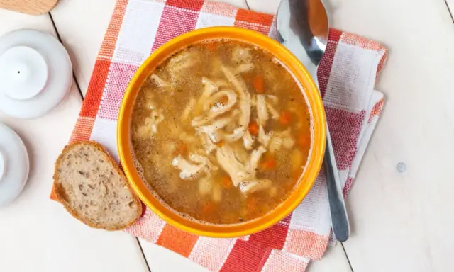 Miseczka gorących flaków, pachnących jak stary przepis na flaki, z kawałkiem chleba i łyżką.