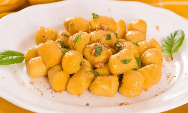Kopytka z dyni wg Gesslerowej, delikatne i aromatyczne, posypane świeżą bazylią i okruszkami.