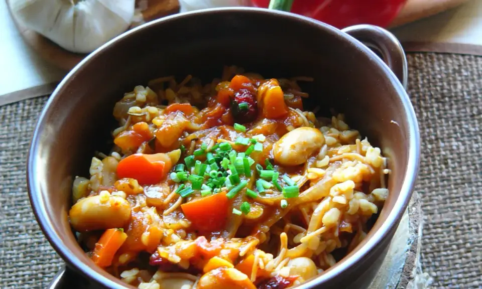 Pyszna kasza bulgur gotowanie z warzywami i fasolą, posypana szczypiorkiem. Aromatyczne danie, które zachwyca smakiem.