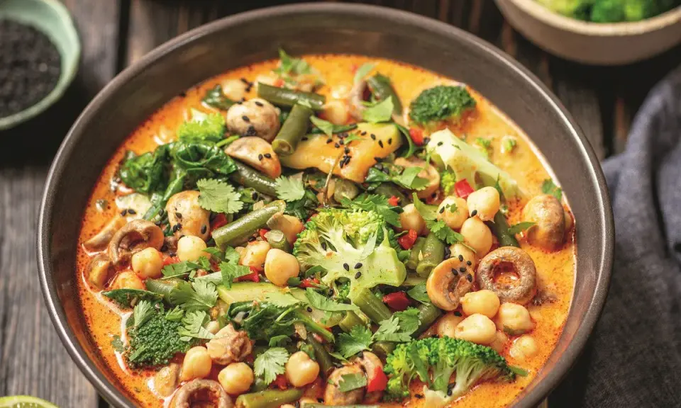 Kremowe curry z ciecierzycą, brokułami, fasolką szparagową i grzybami, posypane czarnym sezamem.