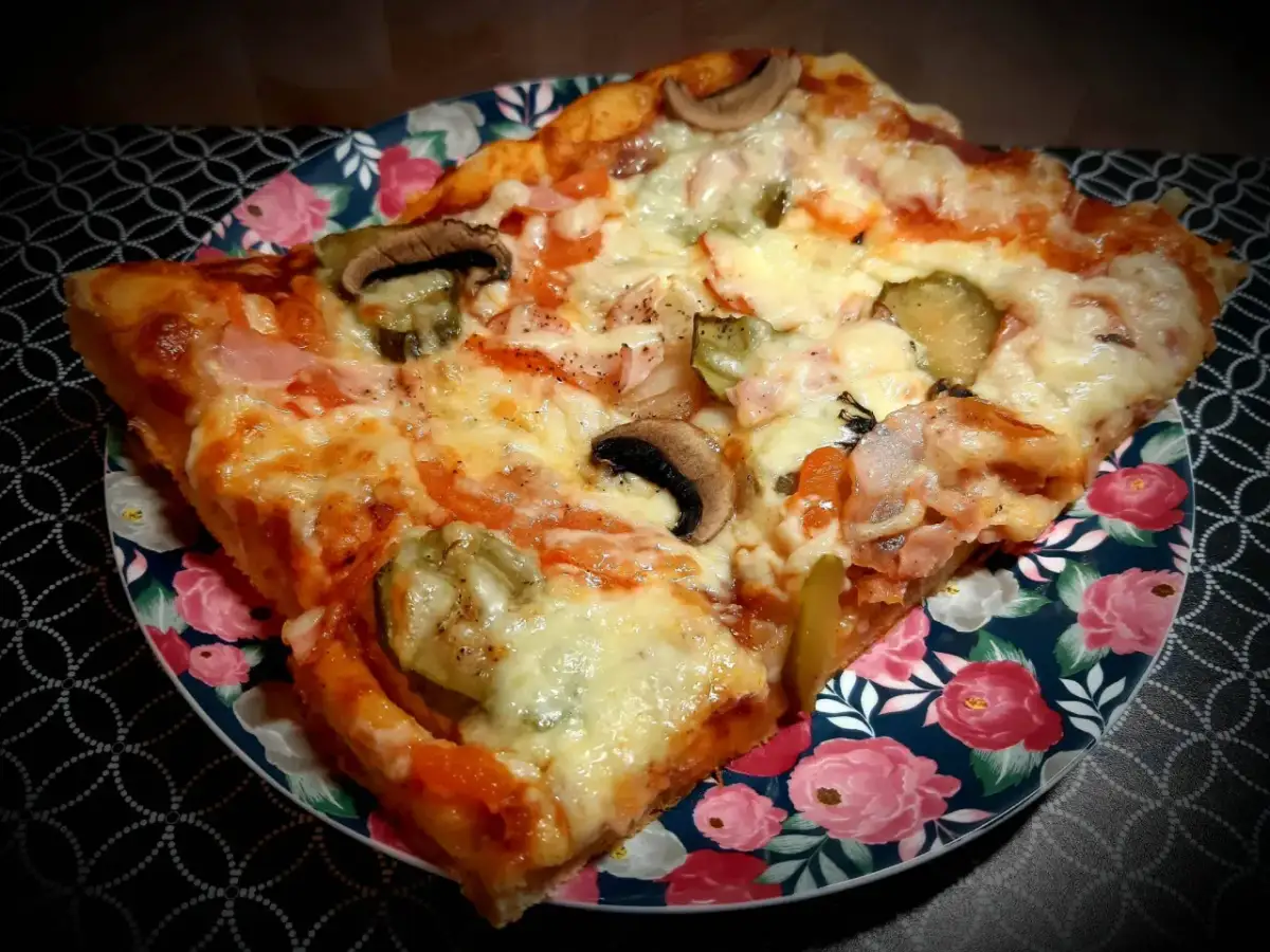 Pyszny domowy przepis na pizzę z pieczarkami, ogórkiem i szynką. Idealna na szybki obiad.