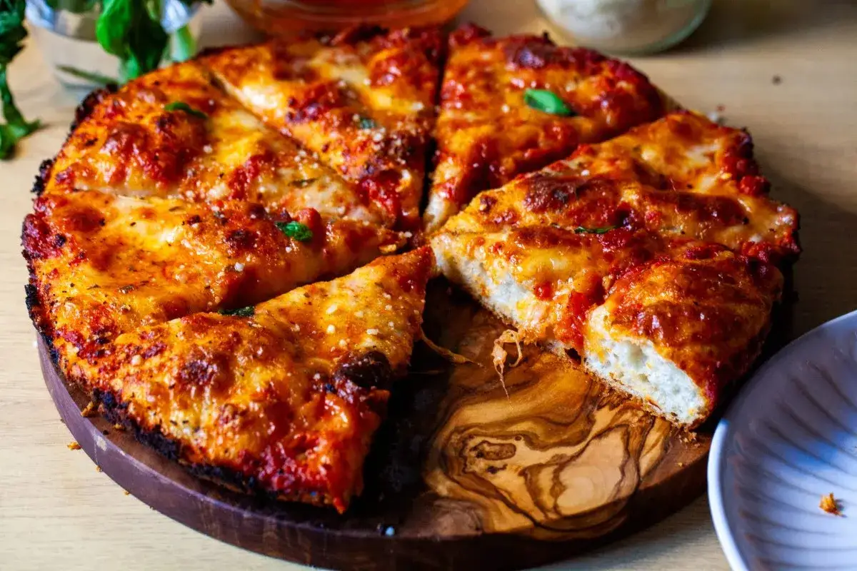 Pyszna pizza na drewnianej desce, idealna na rodzinny obiad. Ten przepis na pizzę zachwyci każdego!