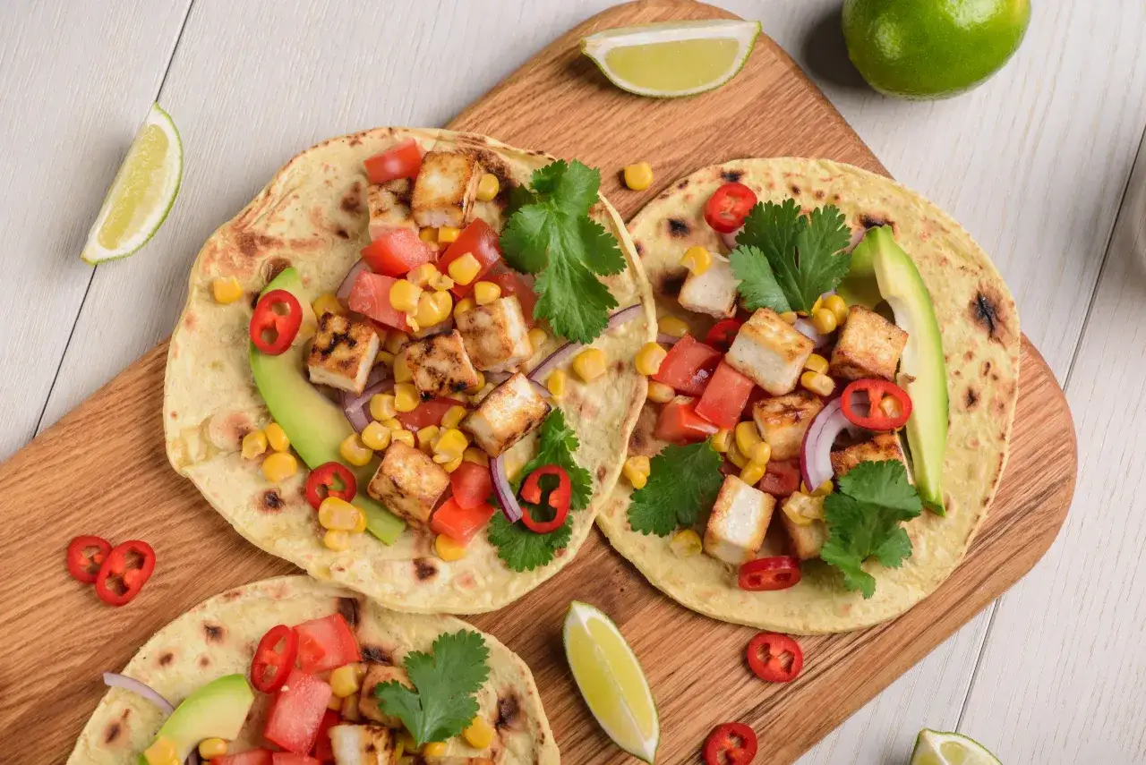 Trzy tortille z grillowanym tofu, kukurydzą, pomidorami, awokado i chili. Idealny prosty obiad o niskim indeksie glikemicznym, podany z limonką.