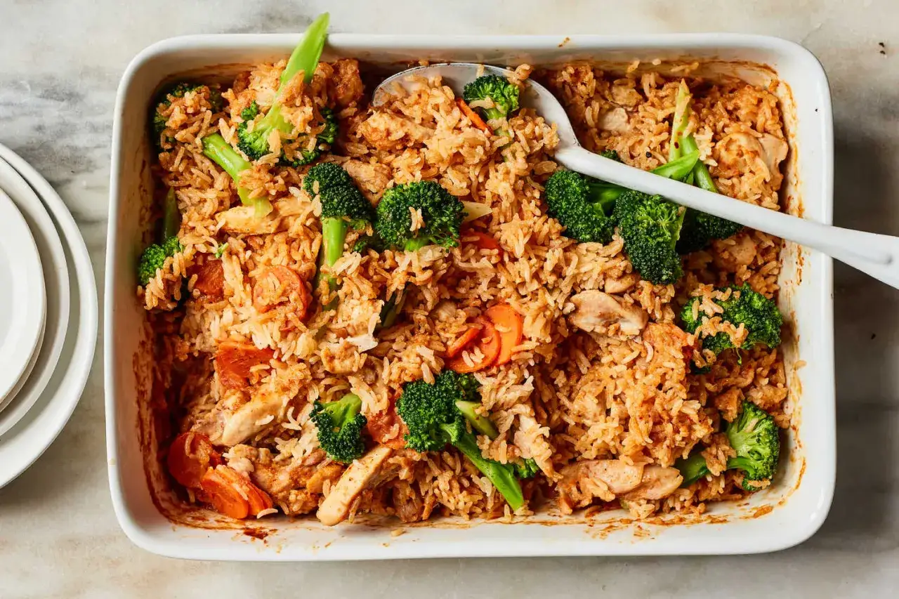 Pyszny ryż z curry z kurczakiem, brokułami i marchewką w naczyniu żaroodpornym.